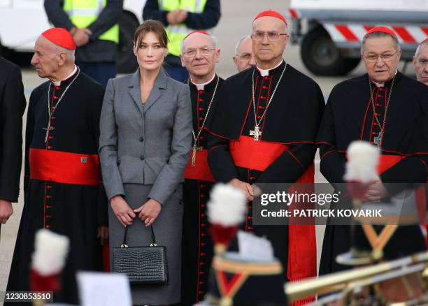 French first lady Carla Bruni-Sarkozy and Vatican Secretary of State Tarcisio Bertone listen to the anthems upon the arrival of Pope Benedict XVI at...