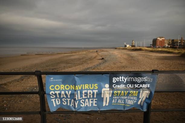 Sign reminding beach-users of the guidance to keep 2-metres away from other people is seen in Fleetwood, northwest England, on January 29, 2021 as...