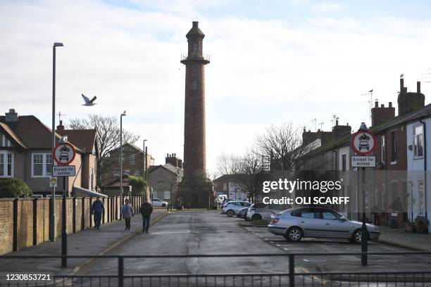 People walk in the street in Fleetwood, northwest England, on January 29, 2021 as life continues in Britain's third coronavirus lockdown. - UK...