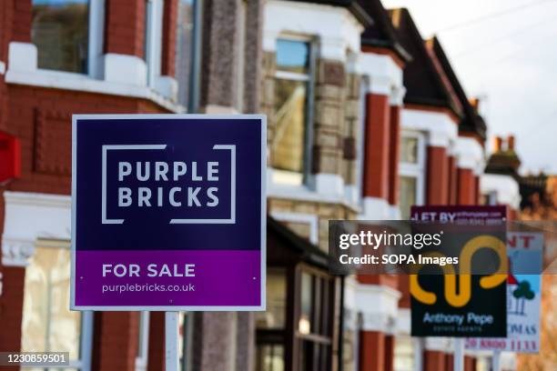 Estate agent boards sign "For sale" erected outside a property in London.