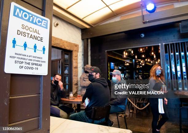 Notice inviting patrons to social distance is seen in the outdoor seating area of The Abbey Food & Bar on January 29, 2021 in West Hollywood,...