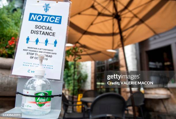 Notice calling for patrons to social distance along with hand sanitizer are seen in the outdoor seating area of The Abbey Food & Bar on January 29,...