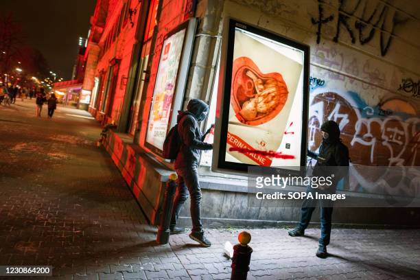 Protesters are seen destroying a pro-life campaign poster on the street during the demonstration. Thousands of people protested for a third...