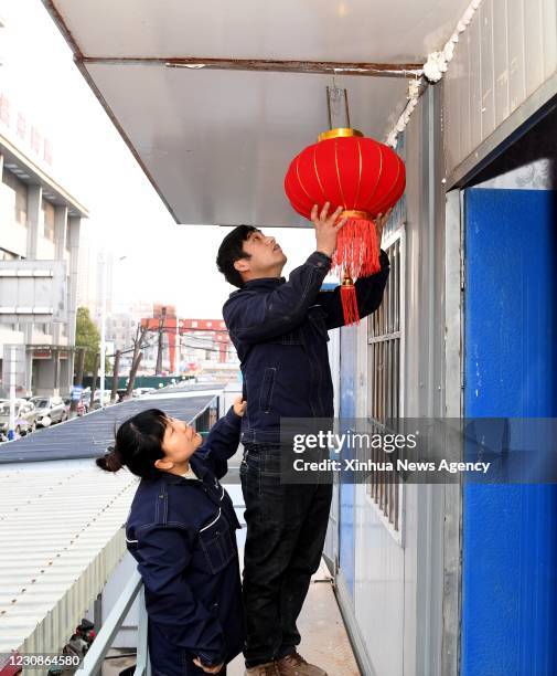 Jan. 29, 2021 -- Sun Hong L and Jia Deku hang lantern outside their dormitory to greet the upcoming Spring Festival in Hefei, capital of east China's...