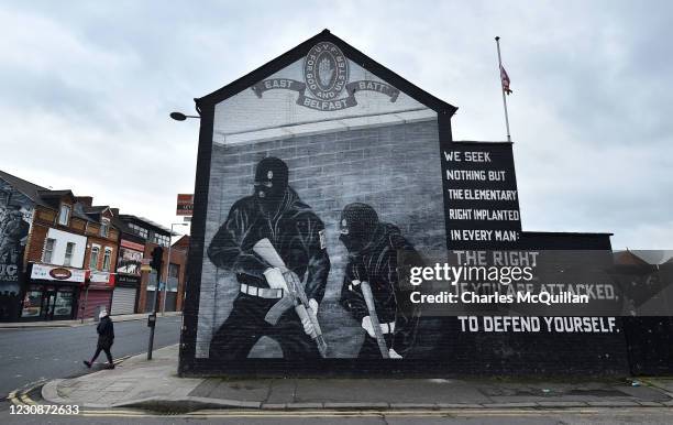 Woman walks past a Loyalist paramilitary mural on the Newtownards road on January 30, 2021 in Belfast, Northern Ireland. The Police Service of...