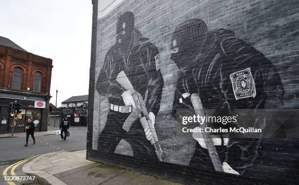 Man and a woman walk past a Loyalist paramilitary mural on the Newtownards road on January 30, 2021 in Belfast, Northern Ireland. The Police Service...