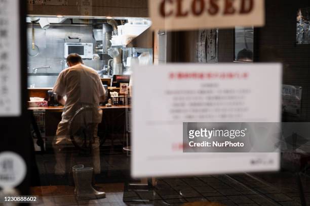 Clerk cleans up at the closed Ramen shop with a sign of shorten business hours due to the state of emergency in Tokyo, Japan on 28 January, 2021.