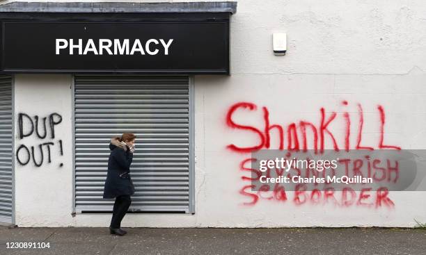 Woman walks past freshly painted loyalist graffiti in the Shankill area on January 31, 2021 in Belfast, Northern Ireland. The Police Service of...