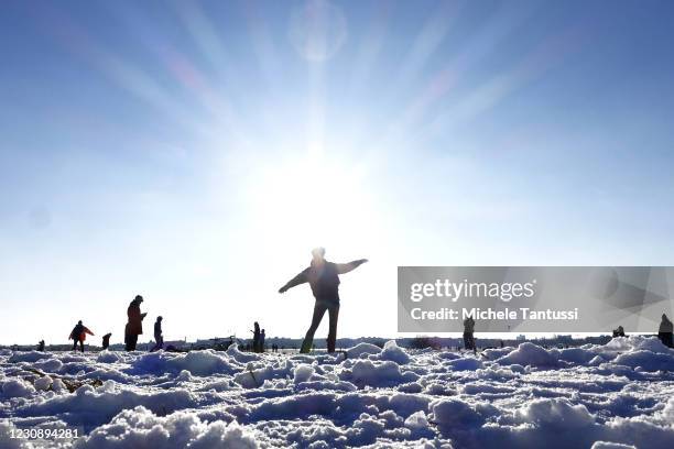 People dance during a spontaneous online streaming dance party at the Tempelhofer Feld Park in a sunny day after heavy Snowfall amid the coronavirus...