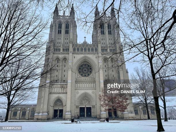 People walk by the front of the closed the Washington National Cathedral on January 31, 2021 after a snowfall in Washington, DC.
