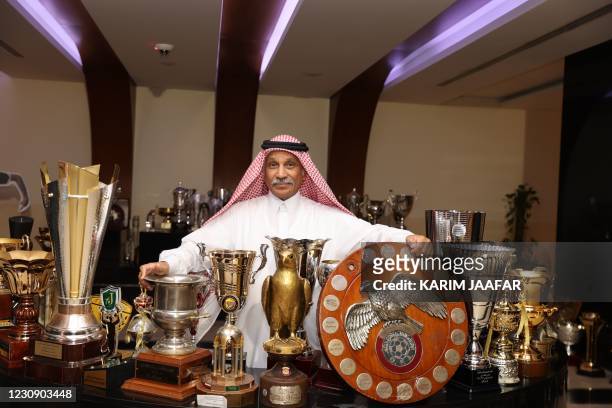 Hassan Mattar, Qatari former striker who played for the Al-Sadd and Qatar clubs, is surrounded with trophies and cups at the headquarters of the...