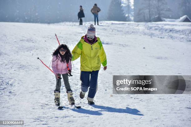 Ski instructor seen helping a young girl in skiing during a sunny winter day at a famous ski resort in Gulmarg. Chillai-kalan", the harshest 40-day...