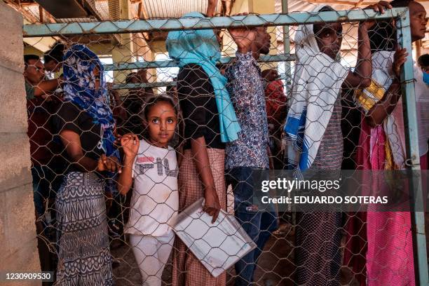 Eritrean refugees queue during a distribution of items organised the United Nations High Commissioner for Refugees at Mai Aini Refugee camp, in...
