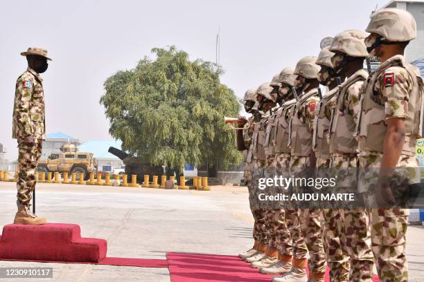 Soldiers stand on attention during a guard of honour for the newly appointed Nigerian military chiefs' arrival at the Maiduguri Airforce base in...