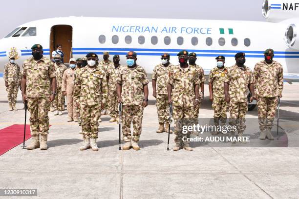 Soldiers stand on attention during a guard of honour for the newly appointed Nigerian military chiefs' arrival at the Maiduguri Airforce base in...