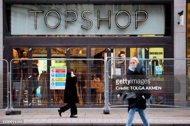 Members of the public walk past a closed branch of the fashion retailer Topshop in central London on February 1, 2021. - UK online retailer ASOS has...
