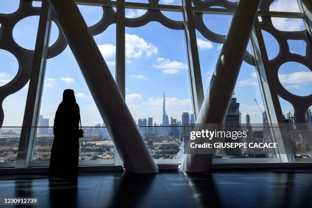 Visitor looks on upon a view of downtown Dubai with the Burj Khalifa while standing at the observation deck of the Dubai Frame on February 1, 2021.