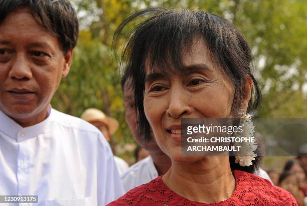 Myanmar opposition leader Aung San Suu Kyi smiles as she leaves after visiting a polling station in the constituency where she stands as a candidate...