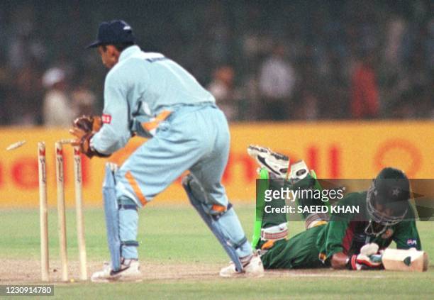 Pakistan batsman Mohammad Wasim dives to regain his crease as Indian wicketkeeper Sabah Karim tries unsuccessfully for a run out during the final...