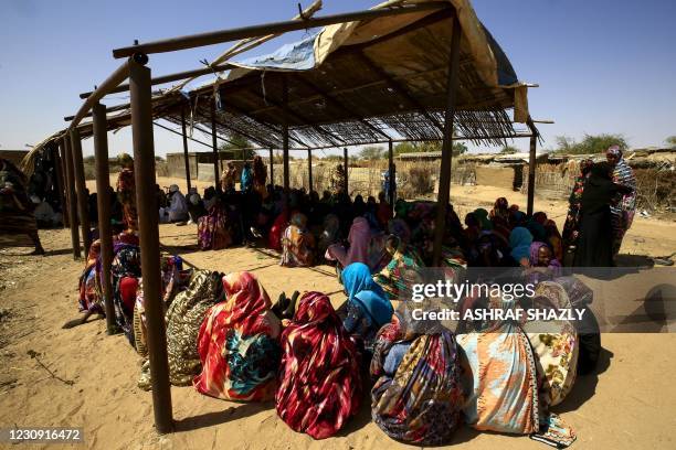 Displaced Sudanese women wait for the arrival of the World Food Programme aid in the Otash internally displaced people's camp on the outskirts of...