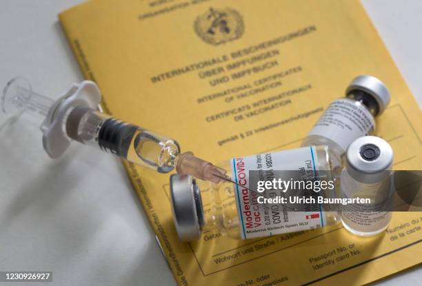 In this photo illustration - vaccination vials from Moderna and Pfizer/BioNTech together with a medical syringe on an international vaccination...