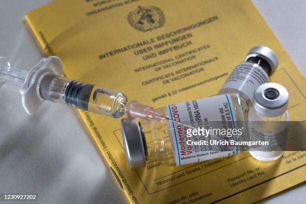 In this photo illustration - vaccination vials from Moderna and Pfizer/BioNTech together with a medical syringe on an international vaccination...
