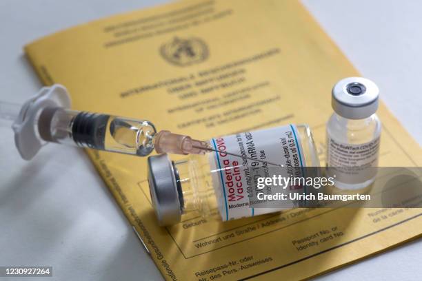 In this photo illustration - vaccination vials from Moderna and Pfizer/BioNTech together with a medical syringe on an international vaccination...