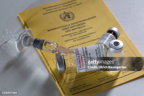 In this photo illustration - vaccination vials from Moderna and Pfizer/BioNTech together with a medical syringe on an international vaccination...
