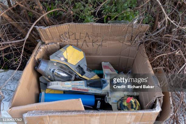 The discarded possessions of a young boy, part of a winter's decluttering, consists of Star War model toys including a Light Sabre and Star Fighter,...