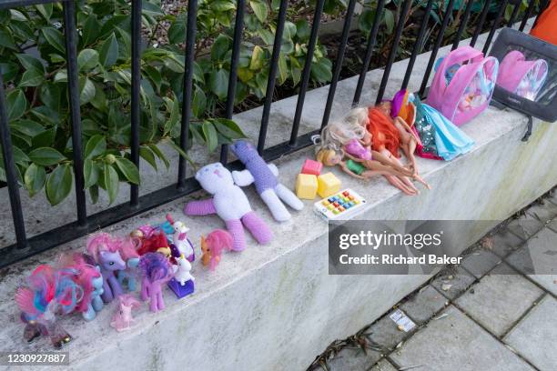 The discarded possessions of a young girl, part of a winter's decluttering, consists of My Little Ponies and Barbie Dolls, which are lined-up on a...