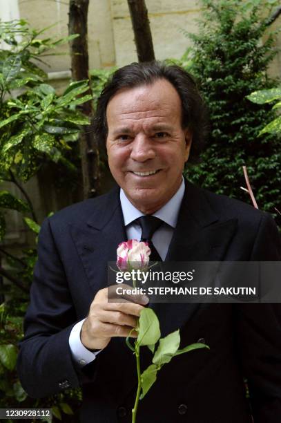 Le chanteur espagnol Julio Iglesias pose une rose à son nom, lors d'une présentation de la variété à la presse, le 28 juin 2007 à Paris. Spanish...