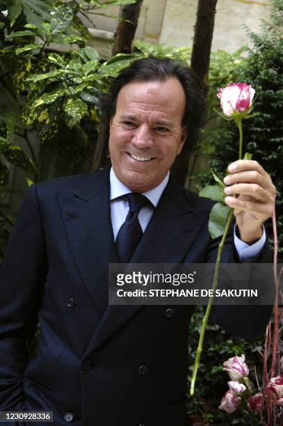 Le chanteur espagnol Julio Iglesias pose une rose à son nom, lors d'une présentation de la variété à la presse, le 28 juin 2007 à Paris. AFP PHOTO...