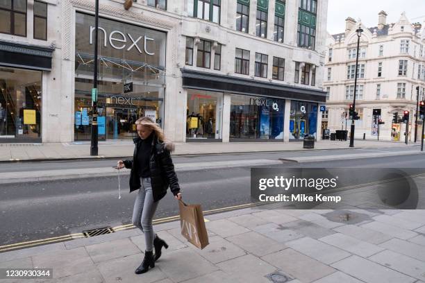 Woman with a Zara bag on Oxford Street which is largely empty of shoppers as the national coronavirus lockdown three continues on 28th January 2021...