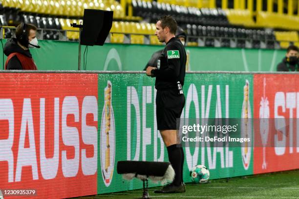 Referee Tobias Stieler looks on the Video Assistant Referee during the DFB Cup Round of Sixteen match between Borussia Dortmund and SC Paderborn 07...