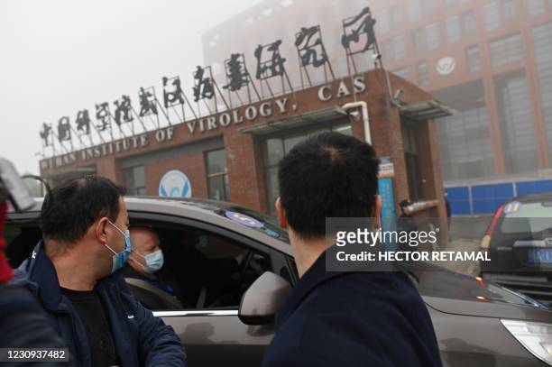 Members of the World Health Organization team investigating the origins of the COVID-19 coronavirus arrive by car at the Wuhan Institute of Virology...