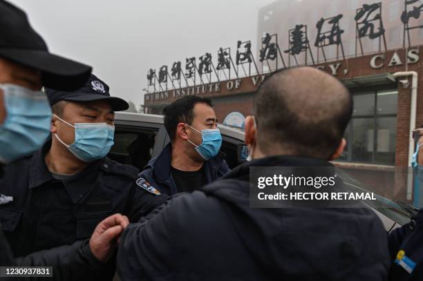 Security personnel are seen as members of the World Health Organization team investigating the origins of the COVID-19 coronavirus, arrive at the...