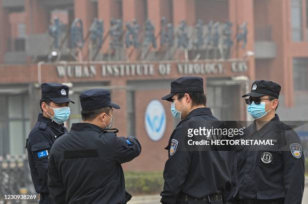 Security personnel stand guard outside the Wuhan Institute of Virology in Wuhan as members of the World Health Organization team investigating the...