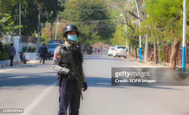 Police officer stands guard outside the Mandalay Chief Minister, Dr. Zaw Myint Maung's House. Following the arrest and release of Dr. Zaw Myint...