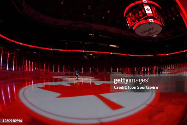 Vancouver Canucks Goaltender Thatcher Demko stands between Canadian Flags projected onto the ice during the anthem prior to their NHL game against...