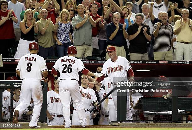 Manager Kirk Gibson and Collin Cowgill of the Arizona Diamondbacks high-five Miguel Montero after he hit a three-run home run against the Colorado...