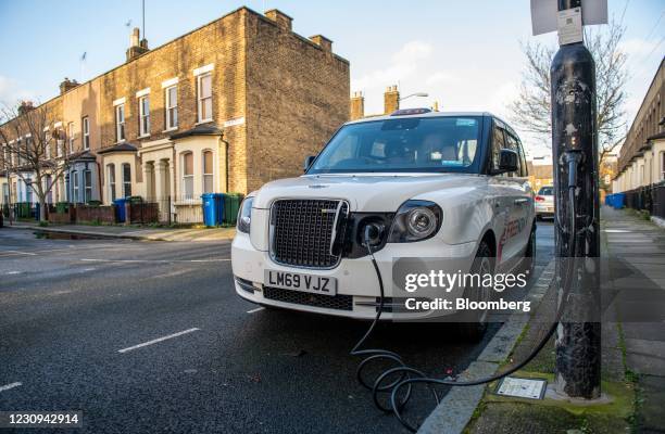 Taxi charges at an Ubitricity plug-in electric vehicle charging station on a residential street in London, U.K., on Tuesday, Feb. 2, 2021. Royal...