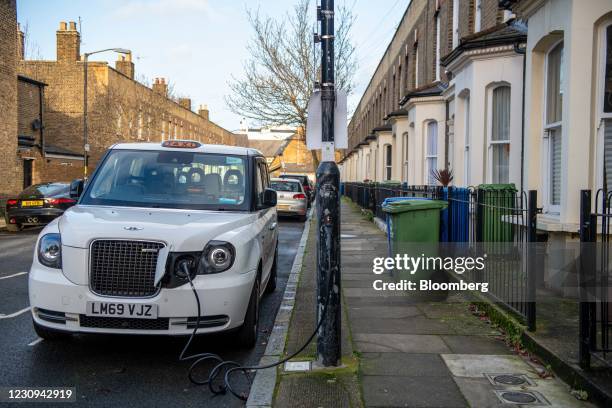 Taxi charges at an Ubitricity plug-in electric vehicle charging station on a residential street in London, U.K., on Tuesday, Feb. 2, 2021. Royal...