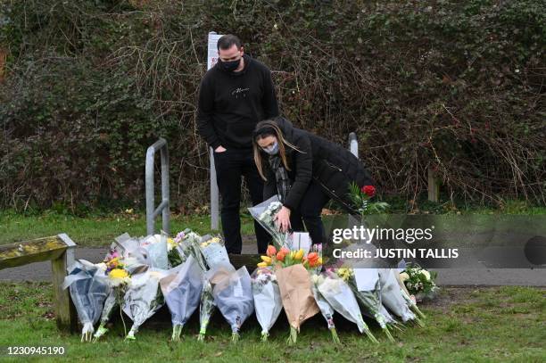 People add flowers to the tributes in the village of Marston Moretaine, north of London on February 3 home of the late Captain Tom Moore following...