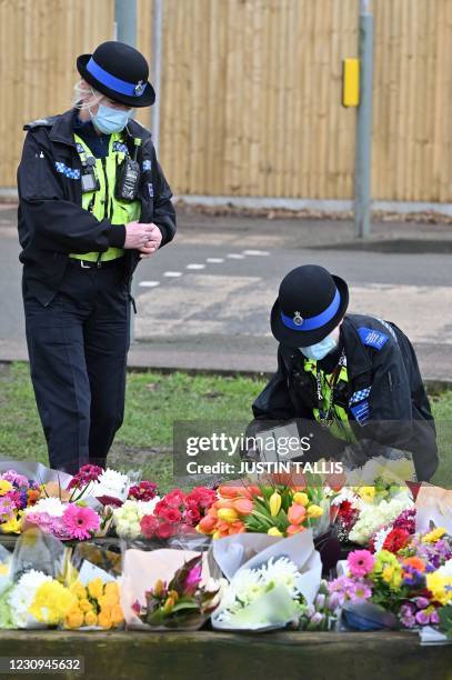 Community police officers lay flowers to the tributes in the village of Marston Moretaine, north of London on February 3 home of the late Captain Tom...