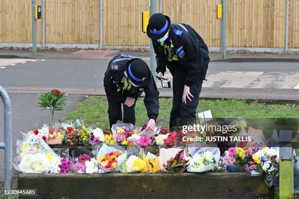 Community police officers lay flowers to the tributes in the village of Marston Moretaine, north of London on February 3 home of the late Captain Tom...
