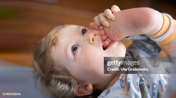 Bonn, Germany In this photo illustration a toddler puts his foot in his mouth on February 02, 2021 in Bonn, Germany.