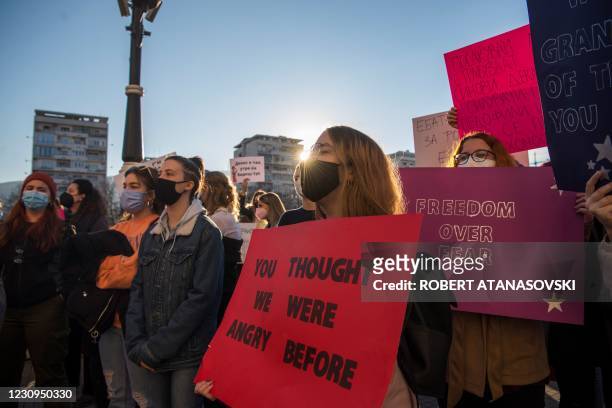 Women hold placards as they take part in a protest march to support women, victims of online harassment, in Skopje on February 3, 2021. - Human...
