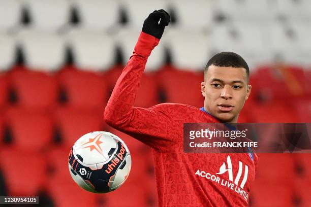 Paris Saint-Germain's French forward Kylian Mbappe eyes the ball as he warms up prior to the French L1 football match between Paris Saint-Germain and...