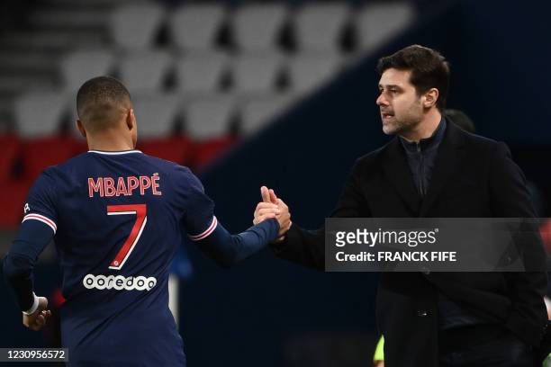 Paris Saint-Germain's French forward Kylian Mbappe celebrates after scoring a goal with Paris Saint-Germain's Argentine head coach Mauricio...
