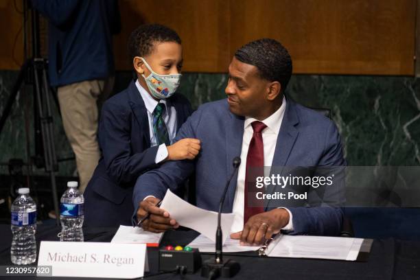 Nominee for Administrator of the Environmental Protection Agency Michael Regan is hugged by his son Matthew after his confirmation hearing before the...